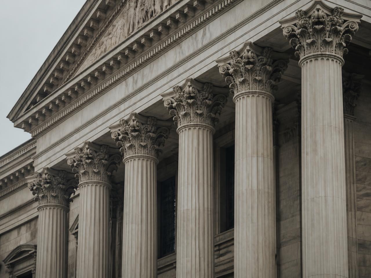 Stone columns and carved cornice of a neoclassical institutional building